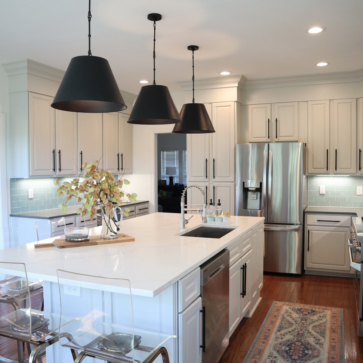 White Nashville kitchen remodel with a large island, black pendant lights, and custom cabinetry
